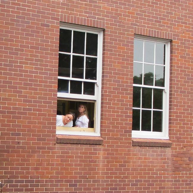 Staff members peer from the school’s windows after the shutdown.