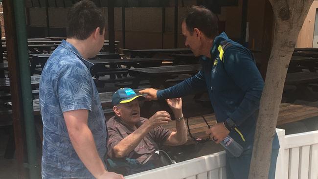 Australian cricket coach Justin Langer gives fan Bill Dean, 80, a cap at training.