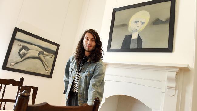 Heide staff member Jake Treacy with some of the other Charles Blackman works on show at the museum — Prone Figure c. 1957 and Blond Schoolgirl c.1954. Picture: Steve Tanner