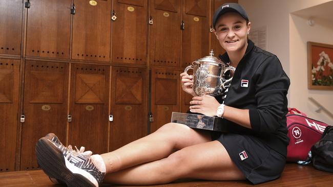 Barty holds the trophy in the locker room. Picture: Picture: Corinne Dubreuil, via AP