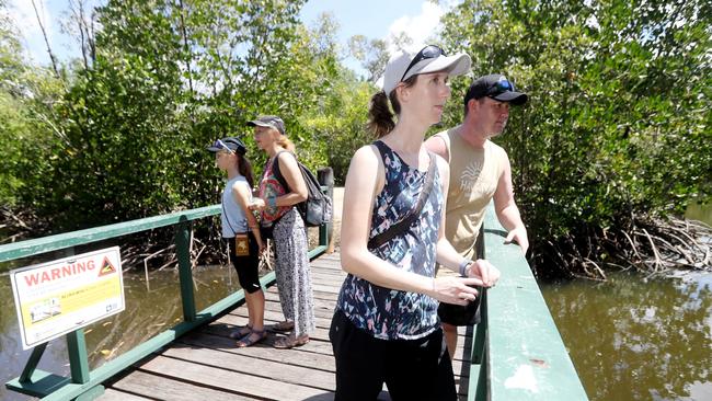 Zara Strelen, 12, and her mother Linda from Brisbane with Sarah Round and John Messfeldt from Melbourne look off the Saltwater Lake footbridge at Centenary Lakes. A sign warning that a crocodile has been spotted in the area has now been affixed to the bridge. Picture: Stewart McLean