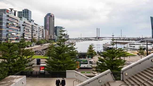 A couple wearing face masks in a deserted Docklands precinct this week. Picture: Asanka Ratnayake/Getty Images