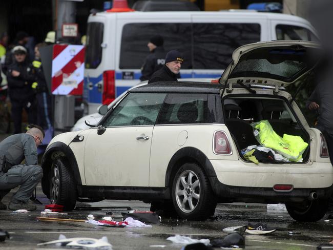 Police and emergency services operate near a damaged car that apparently drove into demonstrators marching in the city centre. Picture: Getty Images