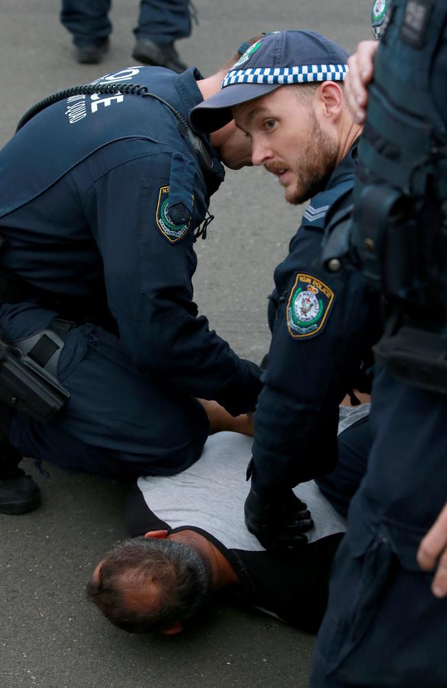 Police arrest a protester outside of the event. Picture: Toby Zerna