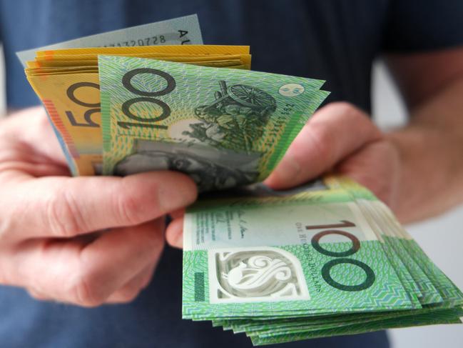 A man counting Australian dollar bills. A picture that describes buying, paying, handing out money, or showing money.  Picture: istock