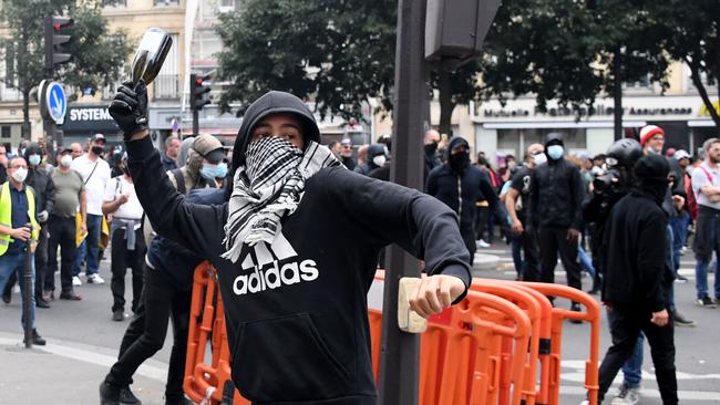 A demonstrator throws a glass bottle at police in Paris. Picture: AFP