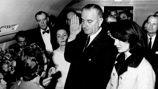 Lyndon B. Johnson (c) with wife Lady Bird Johnson (3rd l) and former First Lady Jacqueline Kennedy during his swearing in ceremony in the cabin of the presidential plane on 22 Nov 1963.