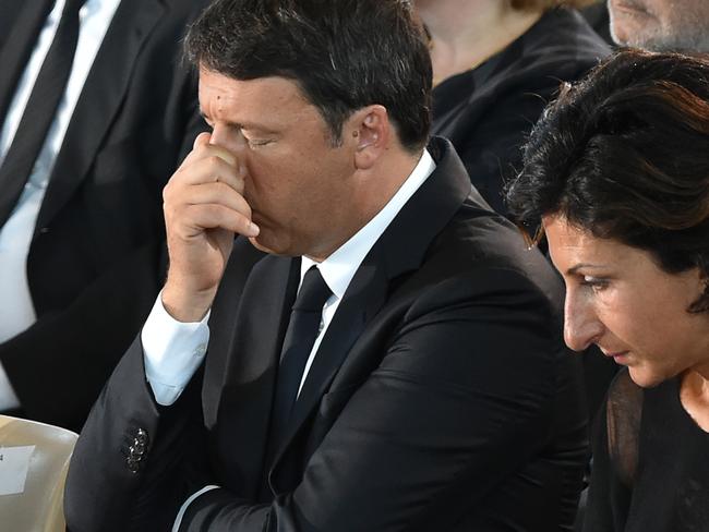 Italian Prime Minister Matteo Renzi (L) and his wife Agnese react during a funeral service for victims of the earthquake. Picture: AFP.