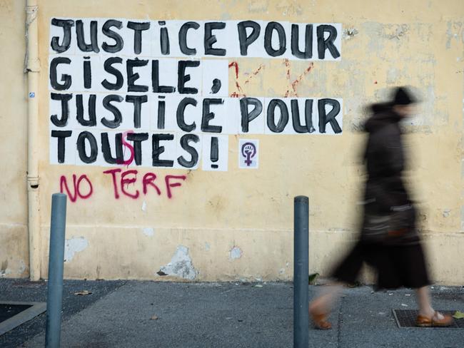 TOPSHOT - A pedestrian walks past a collage mural reading "Justice for Gisele, Justice for all" near the Avignon courthouse where the Mazan rape trial is taking place in Avignon, southern France, on December 16, 2024. In a trial that has shocked the country and whose verdict is expected this week, Dominique Pelicot, 72, has admitted to drugging his then wife Gisele Pelicot for almost a decade so he and strangers he recruited online could rape her. (Photo by CLEMENT MAHOUDEAU / AFP)