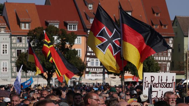 Supporters of the far-right Alternative for Germany (AfD) political party wave German flags. Picture: Getty Images