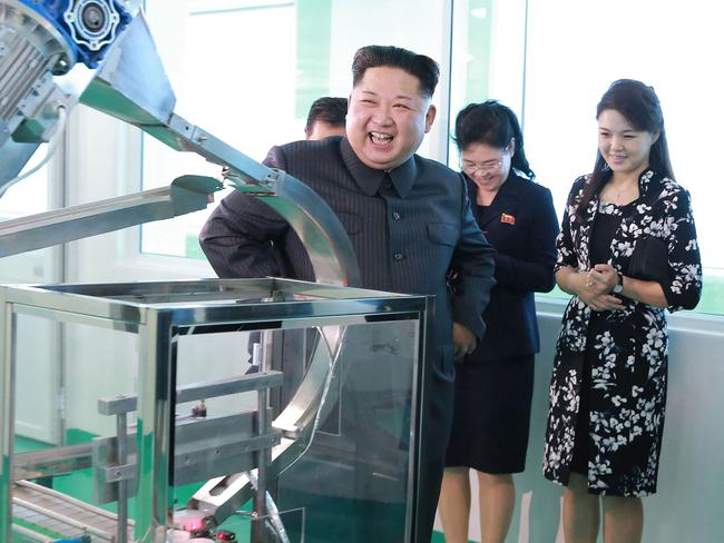 Kim Jong-un enjoys a few LOLs on a tour of the Pyongyang Cosmetics Factory with his wife, Ri Sol-ju (right), looking on dutifully. Picture: AFP/KCNA via KNS