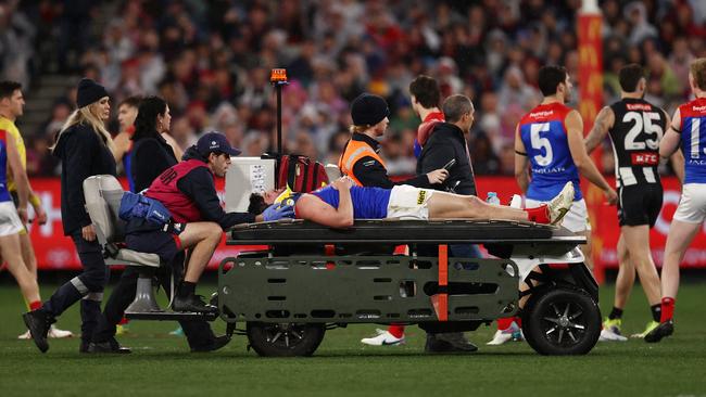 Brayshaw is taken from the ground on a stretcher. Photo by Michael Klein.