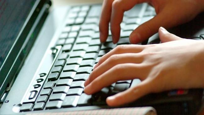 Hands typing on laptop keyboard.