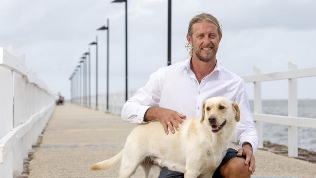 Wynnum resident Ty Clint's poses for a photograph with his dog Sadie on the Wynnum foreshore. (AAP/Image Sarah Marshall)