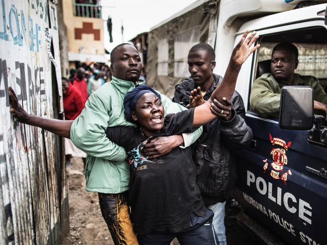 The mother of a man shot in the head allegedly by Kenyan police reacts as she passes a police van transporting her son’s body in an alley of Mathare slum in Nairobi, on August 9, 2017, as unrest broke out a day after general elections. Kenyan police shot dead two protesters in the capital’s flashpoint Mathare slum on August 9, as unrest broke out after opposition accusations that the general election was rigged, a senior officer told AFP. Picture: AFP PHOTO