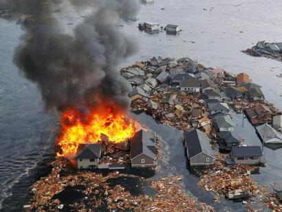 Houses swallowed by tsunami waves burn in Natori, Miyagi Prefecture (state) after Japan was struck by a strong earthquake off its northeastern coast Friday, March 11, 2011. (AP Photo/Kyodo News) MANDATORY CREDIT, NO LICENSING ALLOWED IN CHINA, HONG KONG, JAPAN, SOUTH KOREA AND FRANCE