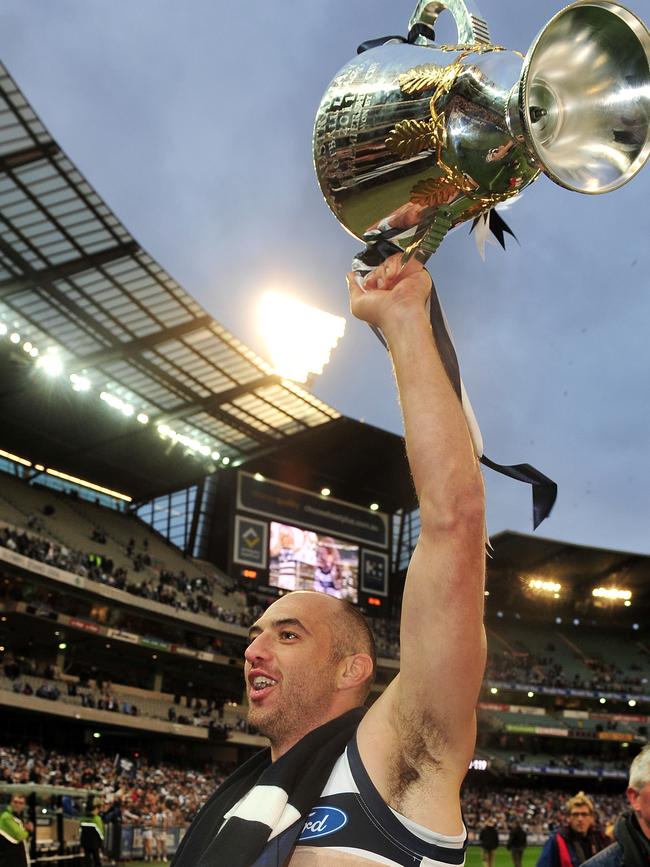 An injured James Podsiadly celebrates Geelong’s 2011 Grand Final triumph.