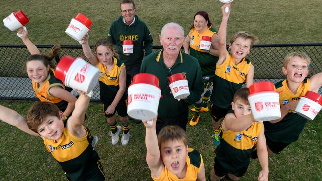 Hampton Rovers life member Bill 'Choc' Mirabito (centre) with club president Gary Nash (left), women’s footballer Catherine Devola with kids and their Salvation Army tins. Picture: Penny Stephens