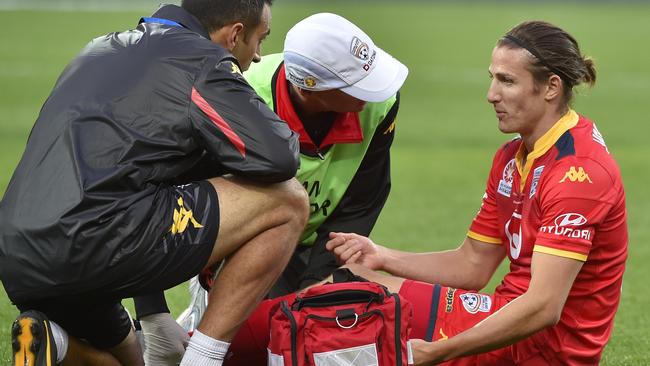 Michael Marrone is checked by Adelaide United medical staff after rupturing his Achilles tendon during the A-League grand final. Picture: David Mariuz (AAP)