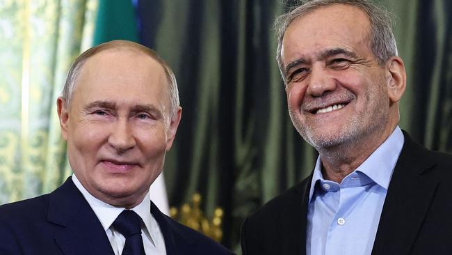 TOPSHOT - Russian President Vladimir Putin and Iranian President Masoud Pezeshkian shake hands during a meeting at the Kremlin in Moscow on January 17, 2025. (Photo by Evgenia Novozhenina / POOL / AFP)