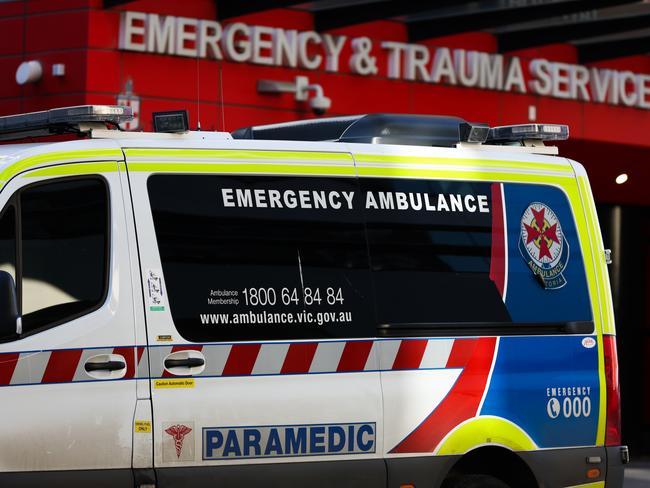 MELBOURNE, AUSTRALIA - JULY 21: An ambulance is parked in front of the Emergency & Trauma service at the Royal Melbourne Hospital on July 21, 2022 in Melbourne, Australia. Victoria recorded 14,312 official cases of COVID-19 in the last 24-hour reporting period, with 875 people hospitalised with the virus, including 46 in intensive care. 37 deaths were also included in this reporting period. While the Federal government has not implemented any COVID-19 restrictions in response to the latest COVID-19 wave, concerns over rising cases of the Omicron subvariants across Australia have seen health authorities recommend the use of face masks indoors, and for people to work from home where possible. (Photo by Asanka Ratnayake/Getty Images)