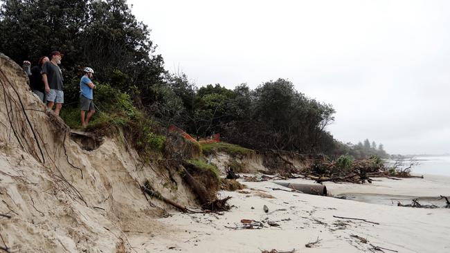 BYRON BAY, AUSTRALIA - DECEMBER 14:  People watch the long stretch of coastal areas seen disappeared due to erosion along the beach side, December 14, 2020 in Byron Bay, Australia. Byron Bay's beaches face further erosion as wild weather and hazardous swells lash the northern NSW coastlines. (Photo by Regi Varghese/Getty Images)