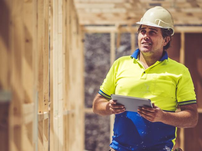 Construction worker on construction site, using digital tablet. He is checking if everything is ok.