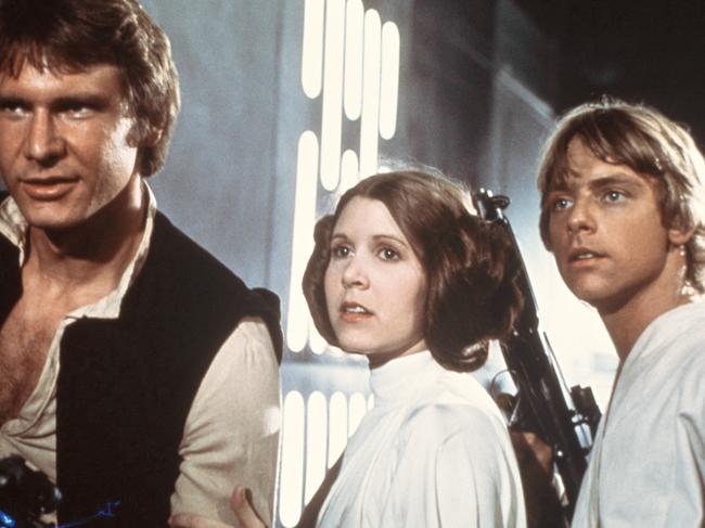 In this 1977 image provided by 20th Century-Fox Film Corporation, from left, Harrison Ford, Carrie Fisher, and Mark Hamill are shown in a scene from "Star Wars" movie released by 20th Century-Fox. Disney is previewing several of the studio's upcoming live-action films for fans at the D23 Expo, Aug. 9-11, 2013, a three-day Disney extravaganza at the Anaheim Convention Center. Disney bought George Lucas' Lucasfilm empire last year for $4.06 billion and plans to unleash a new "Star Wars" trilogy and two spin-off films beginning in 2015 with "Star Wars: Episode VII," which is being directed by J.J. Abrams and written by Michael Arndt. (AP Photo/20th Century-Fox Film Corporation)