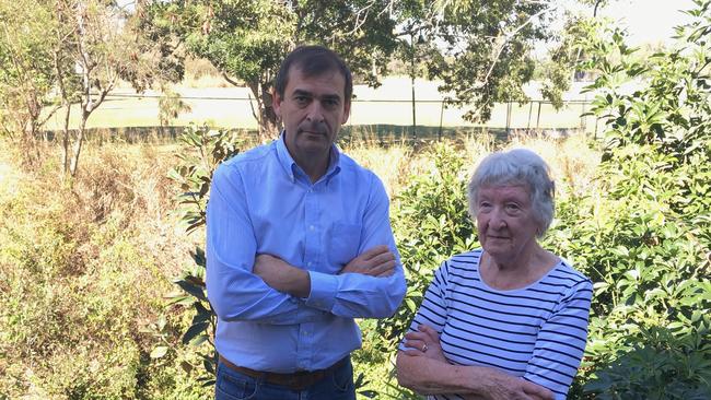 Local residents' action group leader Cameron Russell with Bev Drinkwater in her backyard at Nundah which said started flooding after Airport Link opened. Picture: Darren Cartwright