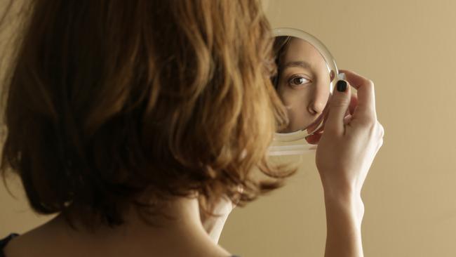 Mirror reflection of a woman's face, studio shot