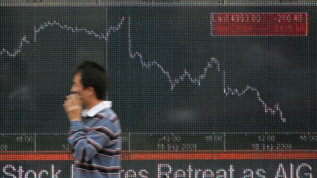 A man walks past an electronic screen in west London which shows the falling FTSE 100 index on September 16, 2008. London's FTSE 100 index of leading shares Tuesday tumbled below 5,000 points for the first time in more than three years as global financial markets continued to suffer from the collapse of Lehman Brothers. The FTSE slumped 3.98 percent to 4,997.20 points -- a level last reached on June 9, 2005. AFP PHOTO/GEOFF CADDICK