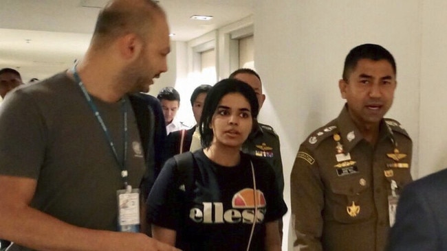 Chief of Immigration Police Maj. Gen. Surachate Hakparn, right, walks with Saudi woman Rahaf Mohammed Alqunun. Picture: AP