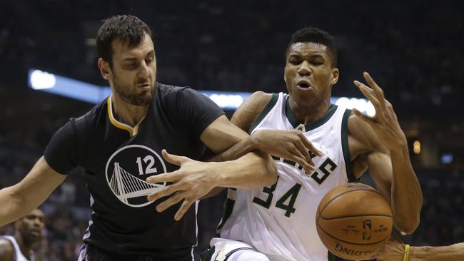 Giannis Antetokounmpo #34 of the Milwaukee Bucks and Andrew Bogut #12 of the Golden State Warriors scramble for a loose ball.