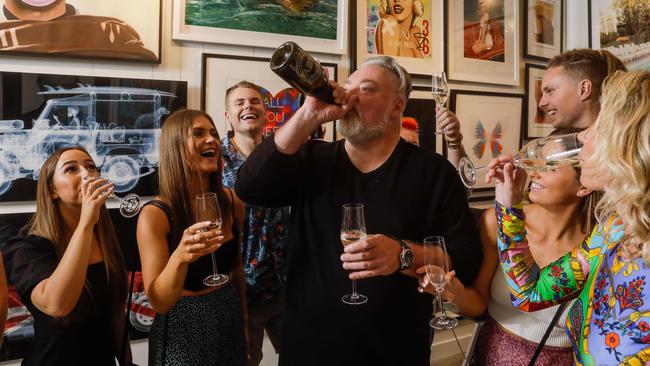 Kyle Sandilands celebrates with friends, including partner Tegan Kynaston, right, at Darren Lyons’ photography gallery in Port Douglas on Tuesday. Picture: Sean Davey