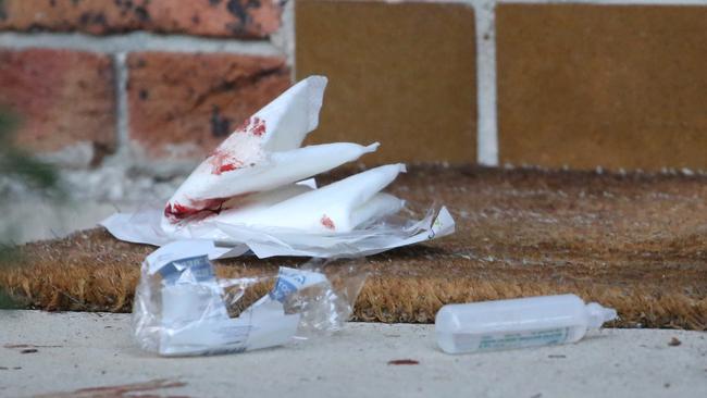 Blood and dressings litter the front door of a neighbouring house. Picture: John Grainger