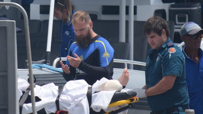 Paramedics treat two men after they were bitten by a shark in the Whitsundays. Picture: Monique Preston