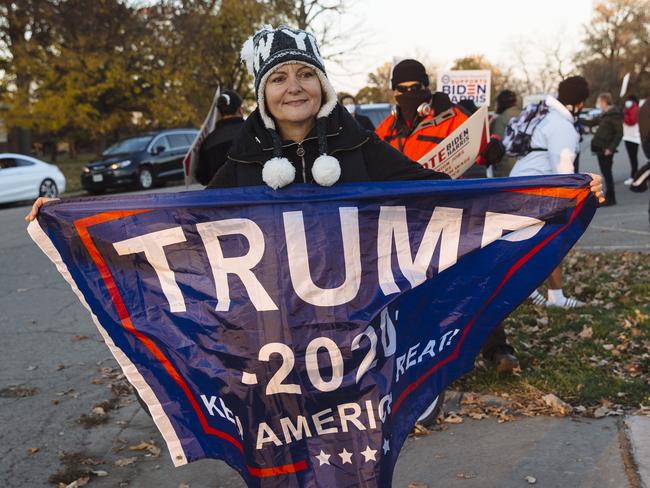 Genevieve Peters, from Detroit, waves a Trump flag among a group of Joe Biden supporters on Belle Isle near where former President Barack Obama was holding a rally with Democratic Presidential Candidate Joe Biden in Detroit. Picture: Angus Mordant