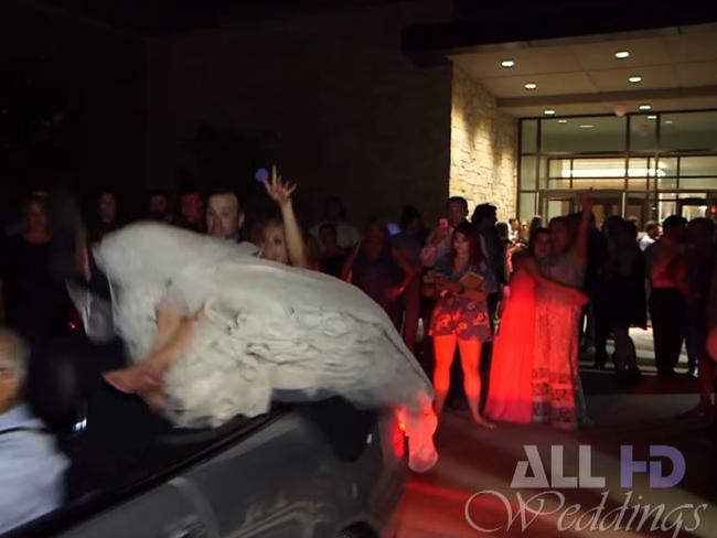 The bride and groom are suddenly thrown off the back of the car. Picture: YouTube