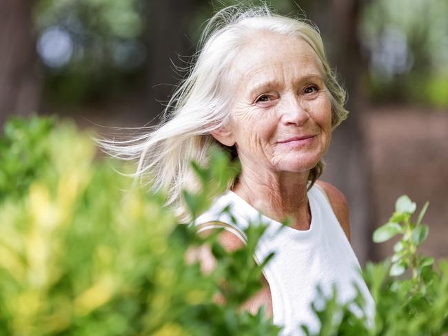 Senior woman walking in the park, background with copy space, full frame horizontal composition. Retiree, retirement generic