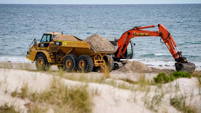 A truck and excavator shifting sand just south of the River Torrens outlet on Monday, May 17, 2021. Picture: Mike Burton