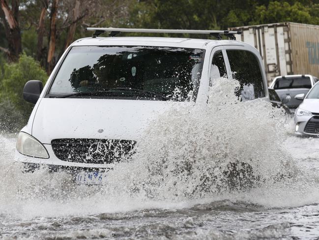 Heavy rain soaks Melbourne causing flash flooding. Cars and trucks negotiate the flooded Dynon Road in West Melbourne.                           Picture: David Caird