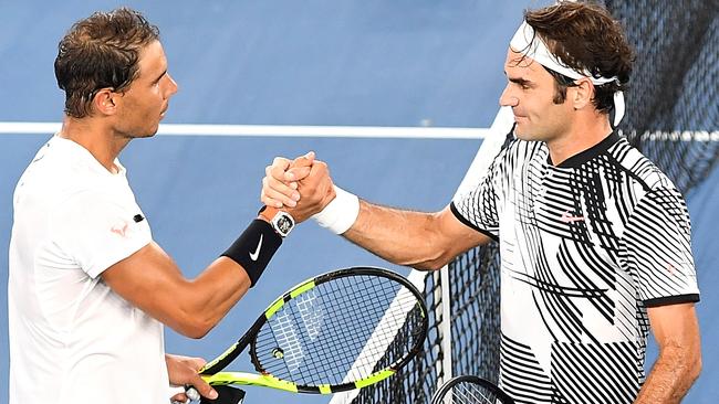 Still brothers, gracious stars Roger Federer and Rafael Nadal meet in the middle of Rod Laver Arena. Picture: AAP