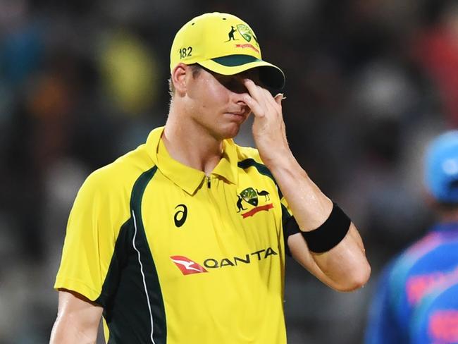 Australia's captian Steve Smith (C) reacts as Indian cricketers celebrate the wicket of Australia's Travis Head during the second one day international (ODI) match of the ongoing India-Australia cricket series at the Eden Gardens Cricket Stadium in Kolkata on September 21, 2017. / AFP PHOTO / Dibyangshu SARKAR / ----IMAGE RESTRICTED TO EDITORIAL USE - STRICTLY NO COMMERCIAL USE----- / GETTYOUT