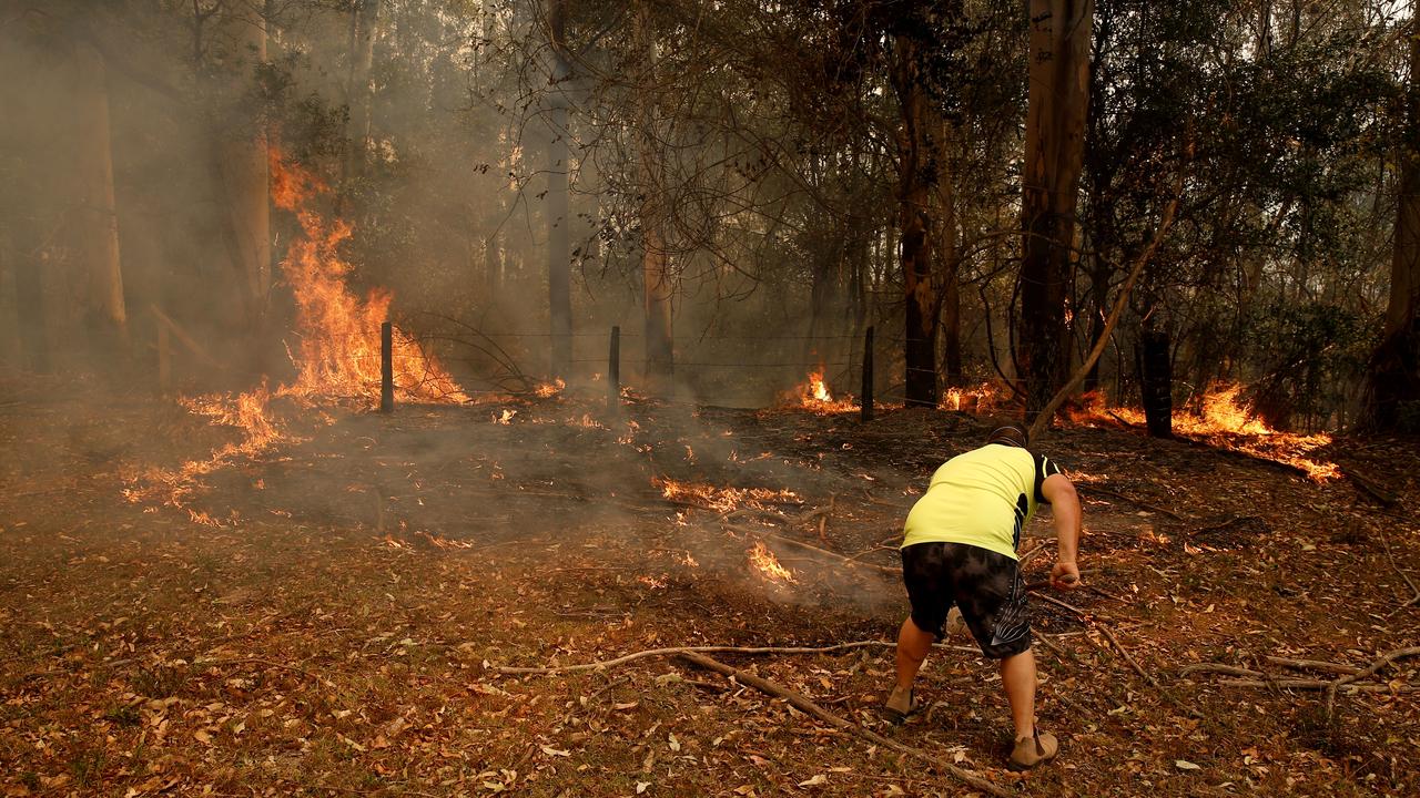 Jamie Fato fights a blaze on a property at Koorainghat, near Taree. Picture: AAP