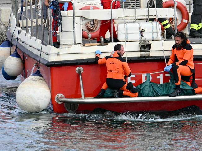 Divers of the Vigili del Fuoco, the Italian Corps. of Firefighters arrive with a body bag at the back of the boat in Porticello near Palermo. Picture: AFP