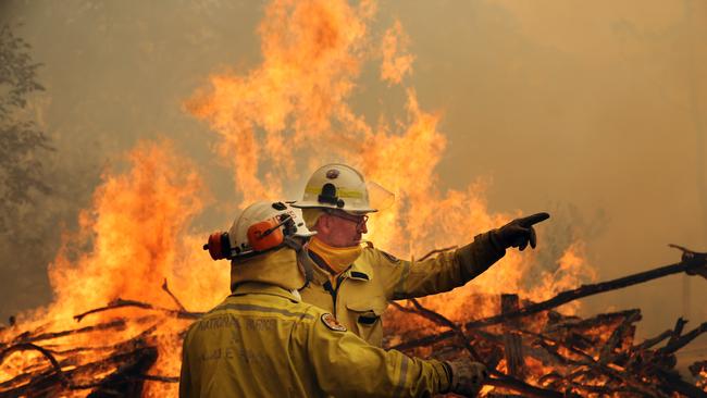 RFS and Forestry firefighters carry out property protection on remote properties near Termeil last Wednesday. Picture Gary Ramage