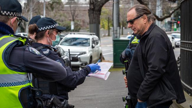 A protester is issued with a fine. Picture: Jake Nowakowski