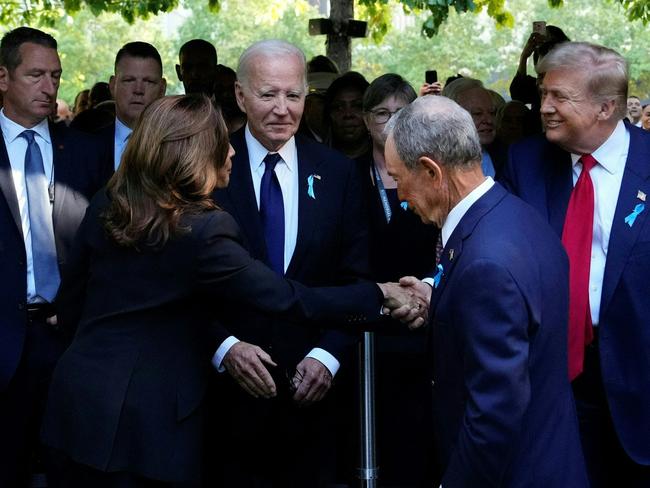 TOPSHOT - US Vice President and Democratic presidential candidate Kamala Harris (L) shakes hands with former US President and Republican presidential candidate Donald Trump (R) as former Mayor of New York Michael Bloomberg (C) and US President Joe Biden (2L) look on during a remembrance ceremony on the 23rd anniversary of the September 11 terror attack on the World Trade Center at Ground Zero, in New York City on September 11, 2024. (Photo by Adam GRAY / AFP)