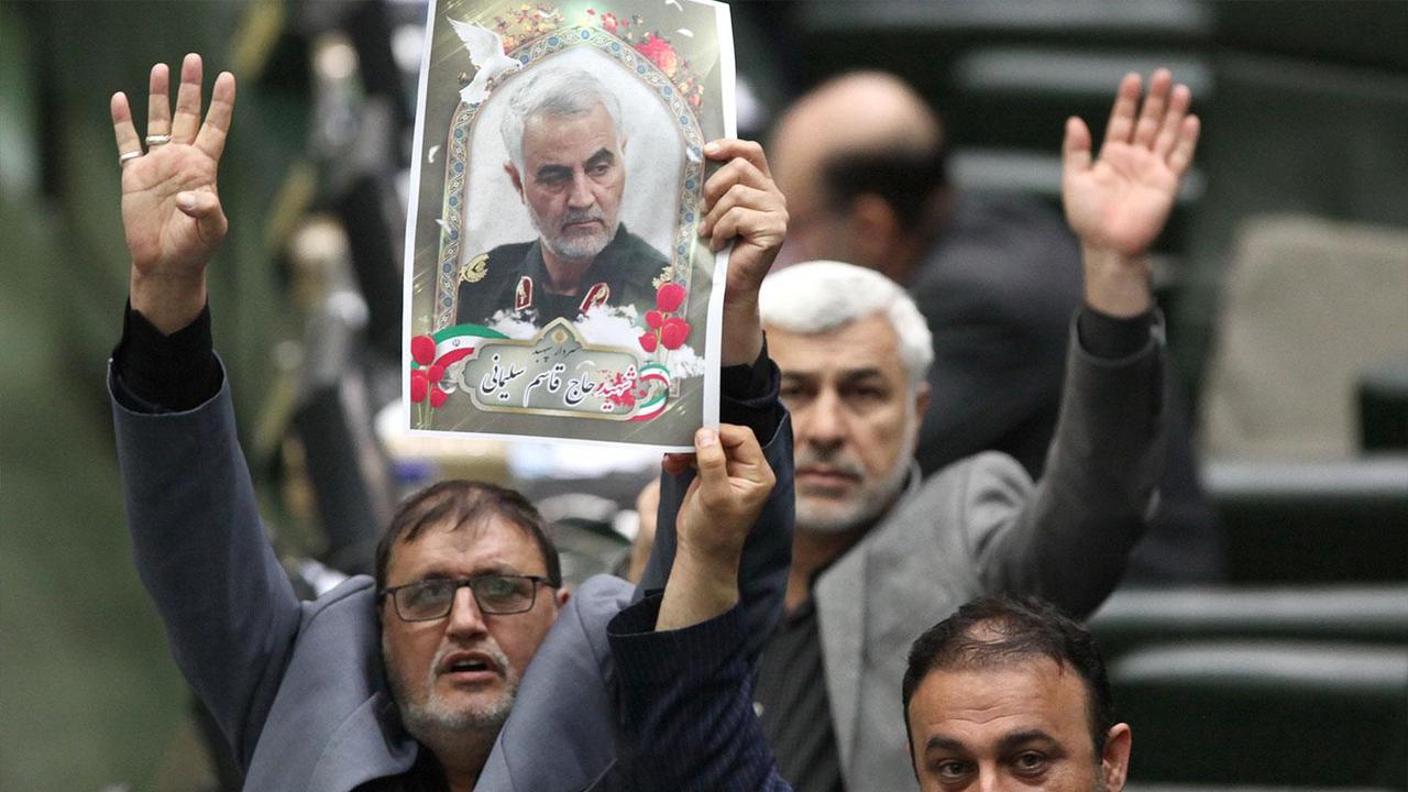 Iranian politicians holding pictures of slain top general Qasem Soleimani as they vote during a parliamentary session in Tehran. Picture: Icana News Agency / AFP