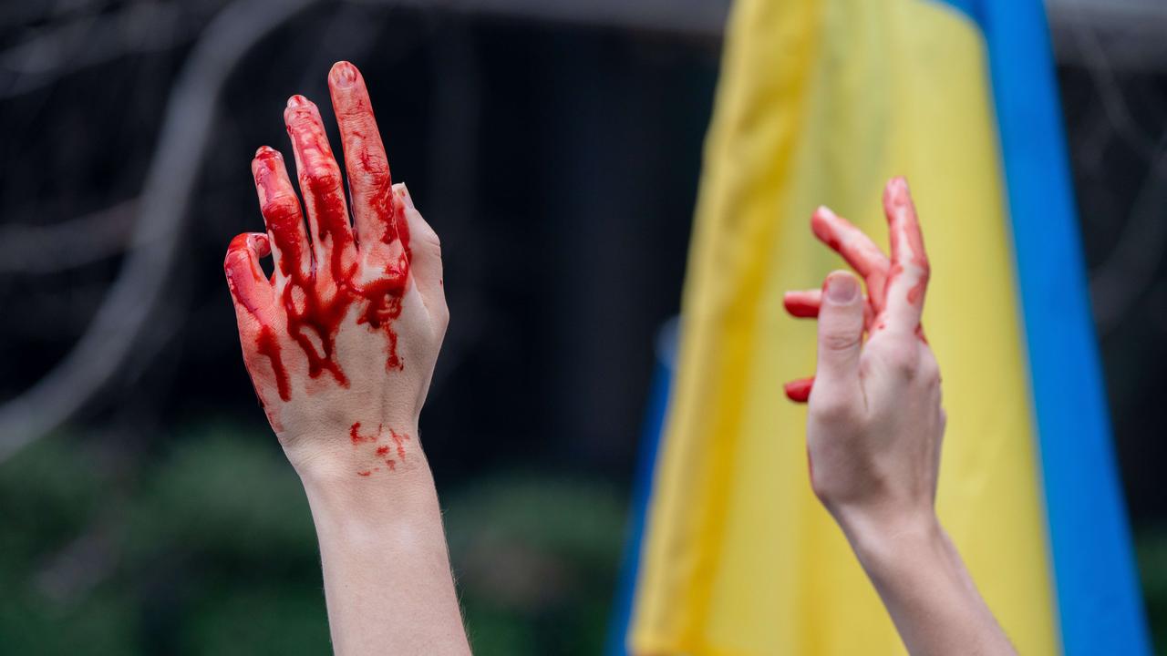 A person with fake blood holds their hands up during a "Stand With Ukraine" rally in New York City. Picture: David Dee Delgado/Getty Images/AFP